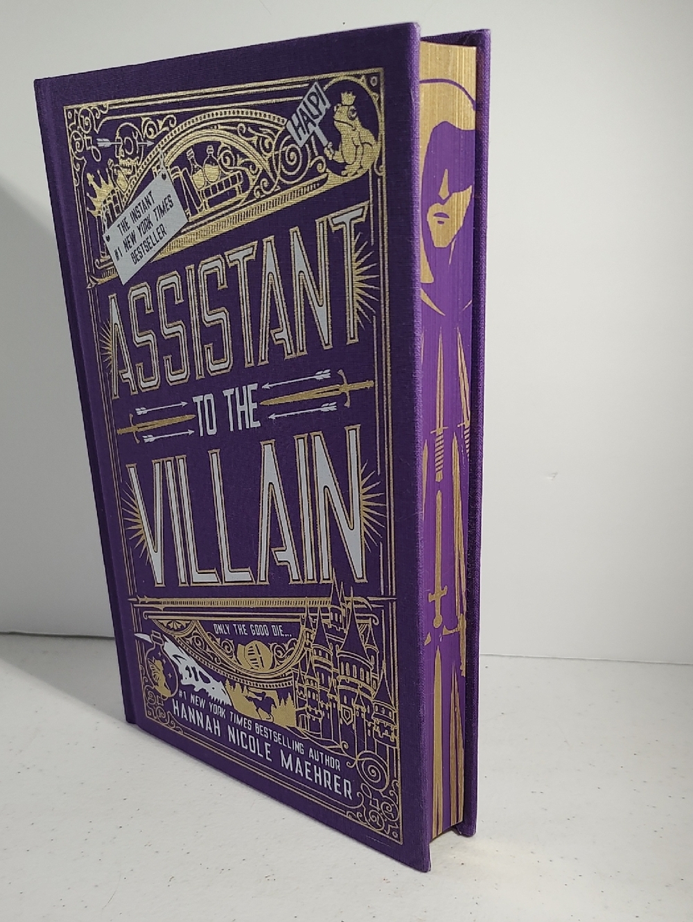 Assistant To The Villain By Hannah Nicole Maehrer Hard Cover Purple With Gold